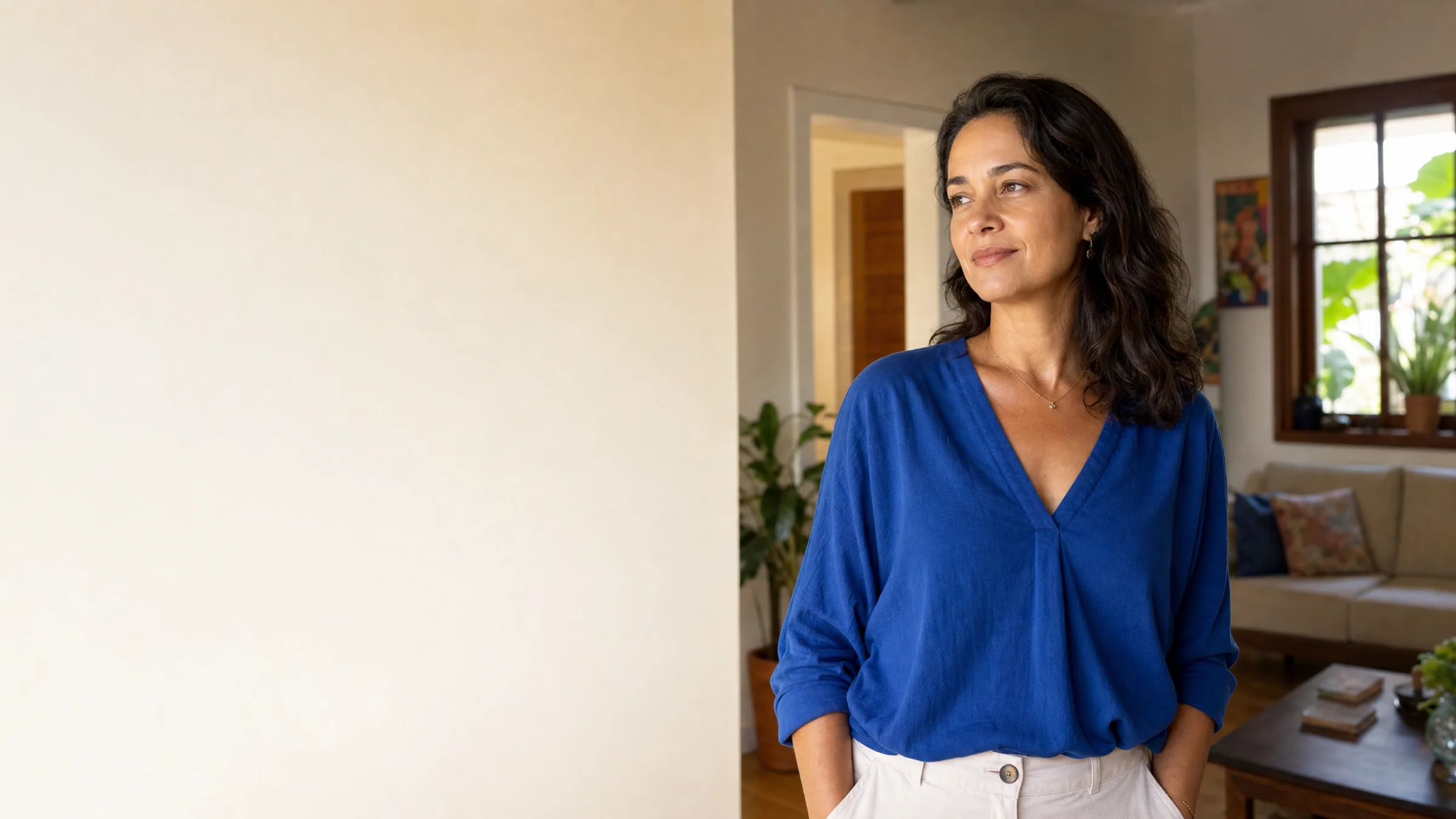 Mulher sorrindo em pé na sala de casa